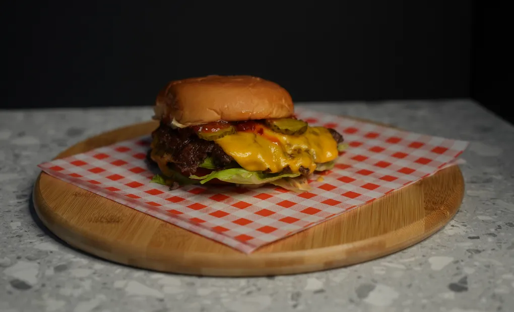 Cheeseburger on a checked paper and board, straight from the camera